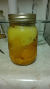 A small mason jar filled 3/4 of roasted yellow peppers, topped with olive oil marinade